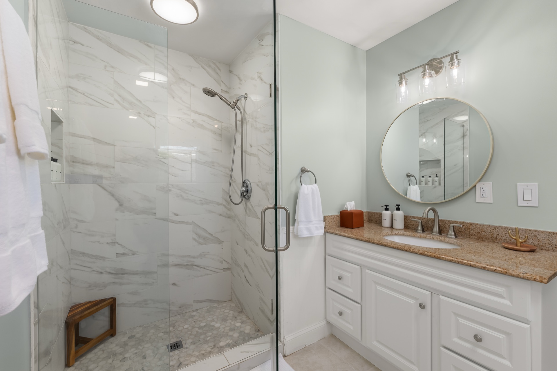 Bathroom vanity at Shell Yeah with granite counters and a walk-in shower