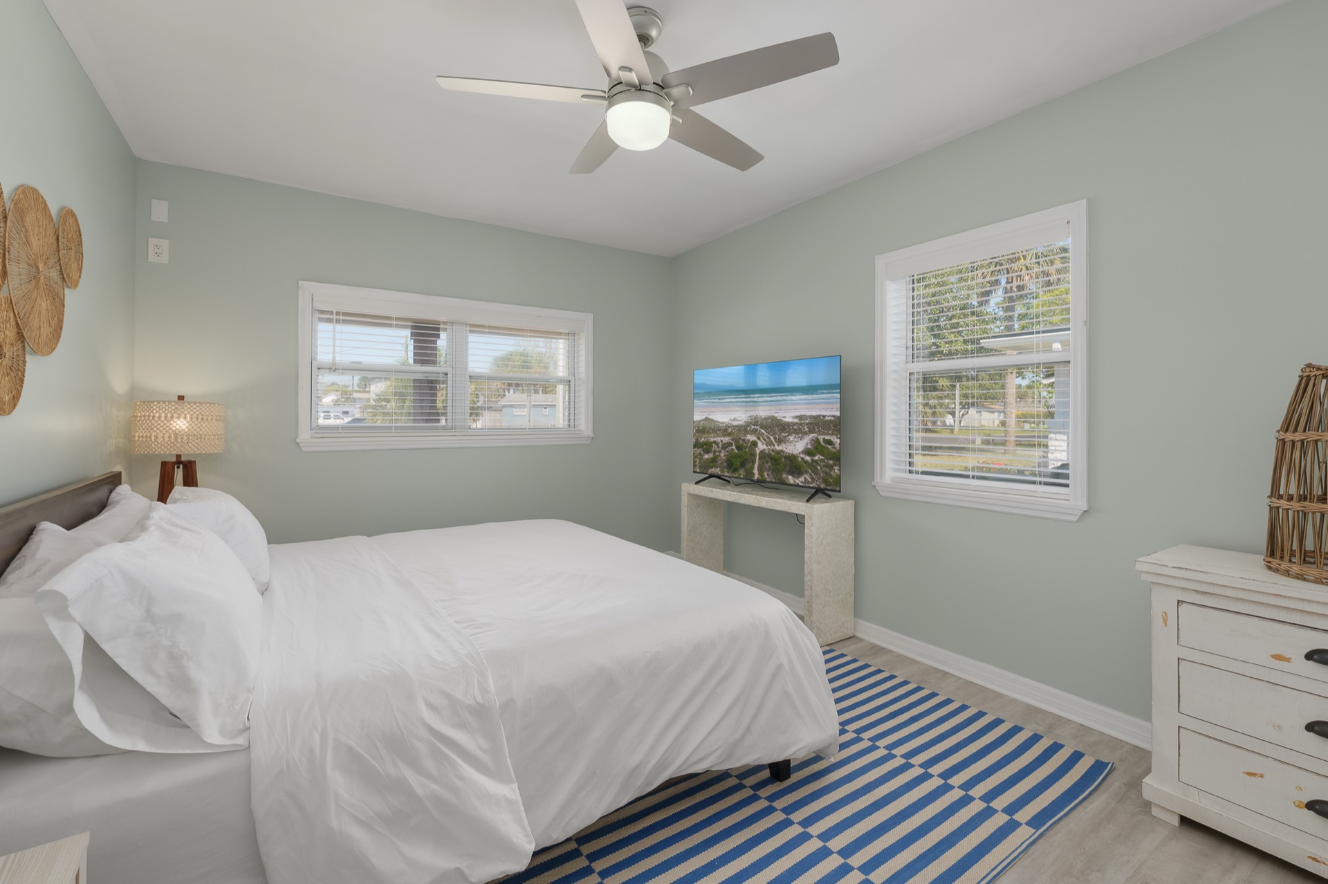 One of four bedrooms at Shell Yeah with crisp white linens and a coastal color palette