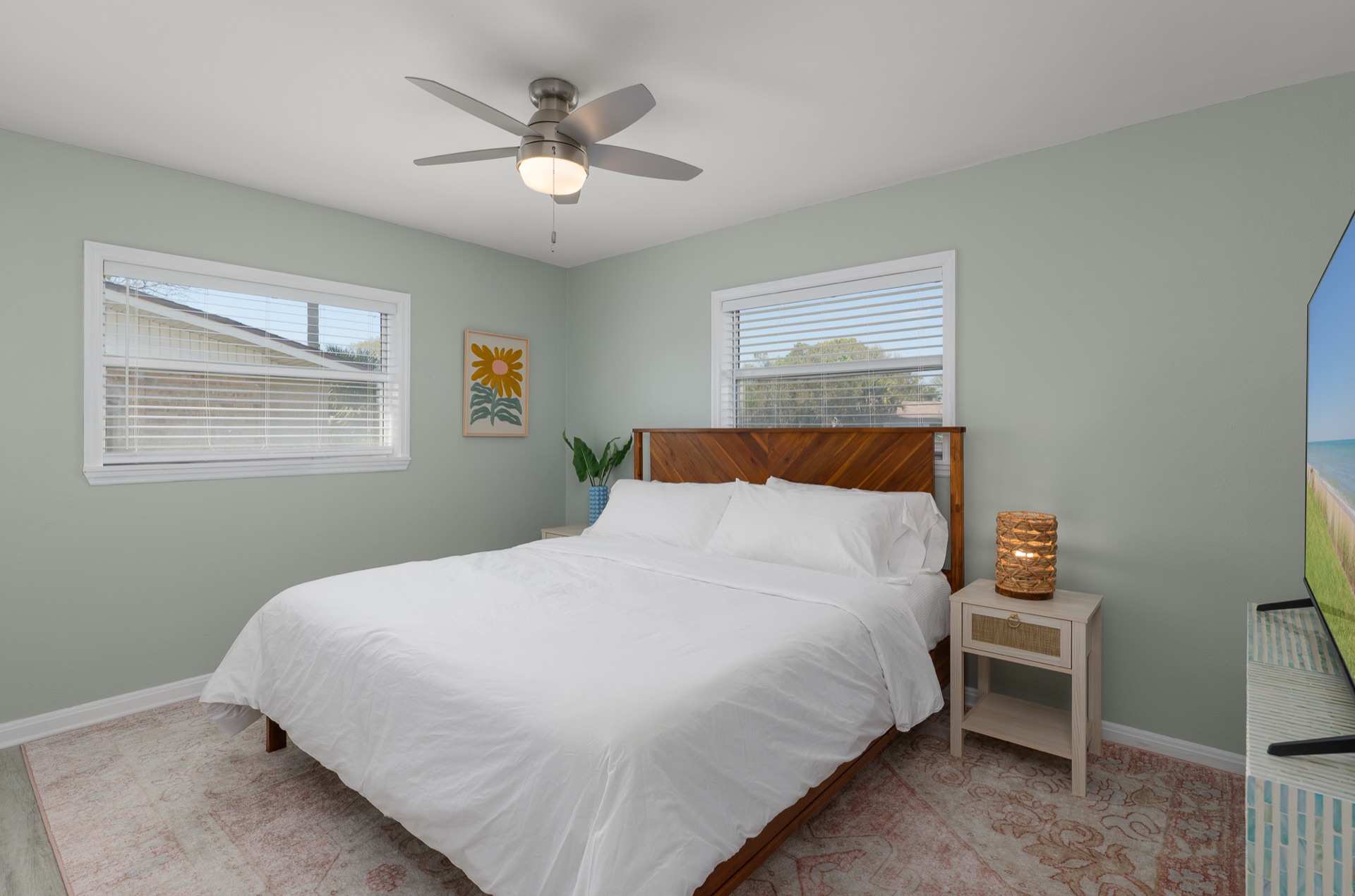 A third bedroom at Shell Yeah with a wood chevron headboard and playful coastal art