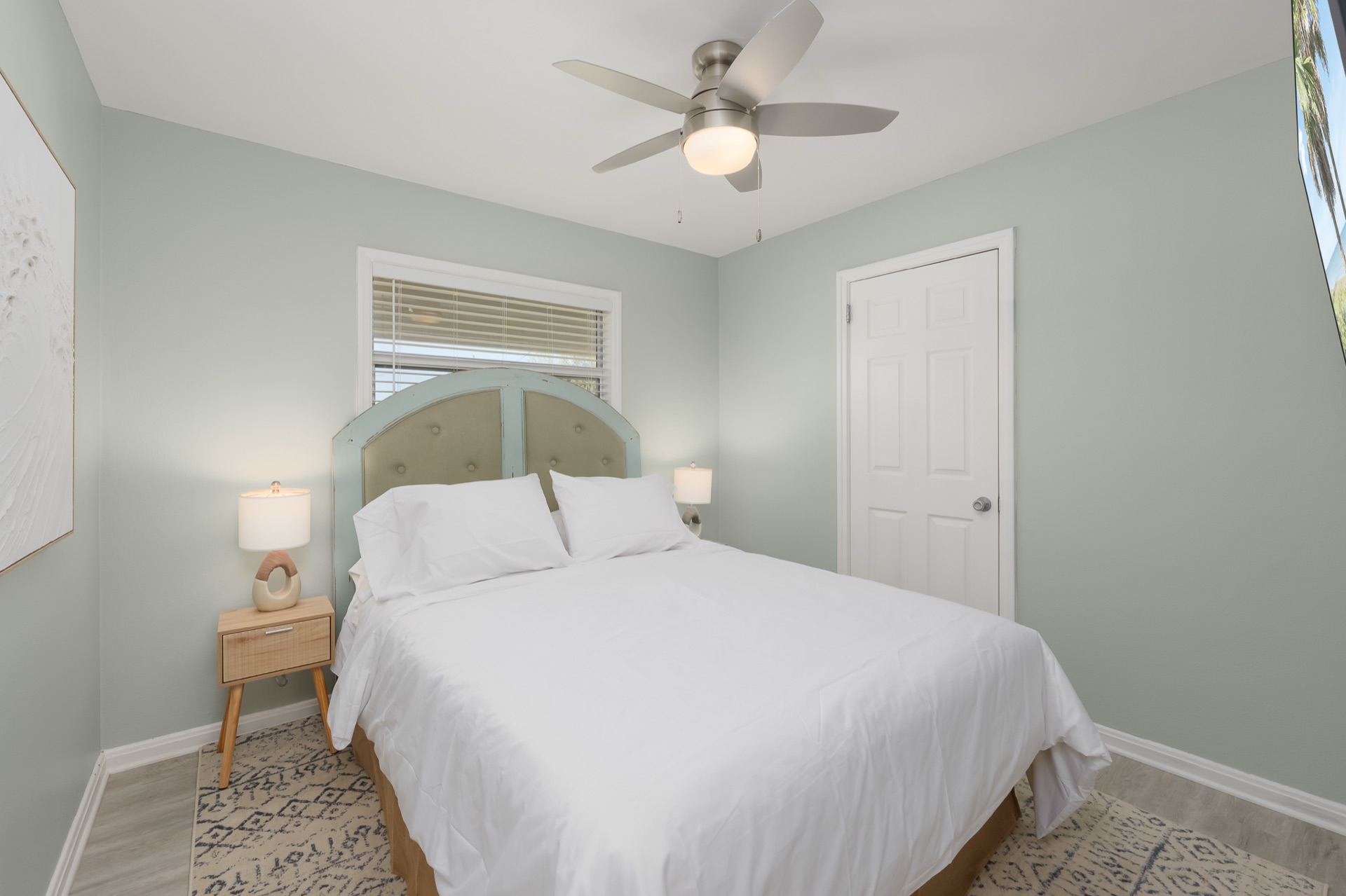 The fourth bedroom at Shell Yeah with a vintage arched tufted headboard