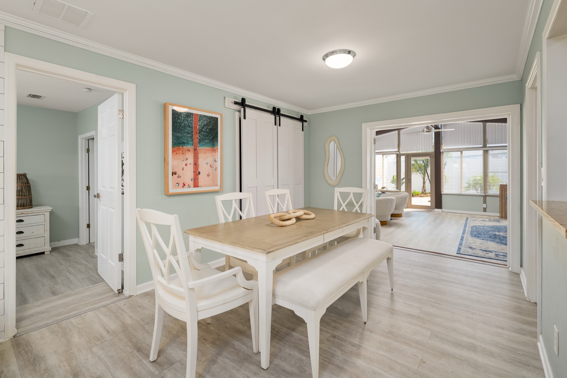 Dining room at Shell Yeah with a sliding barn door and a view into the sunroom