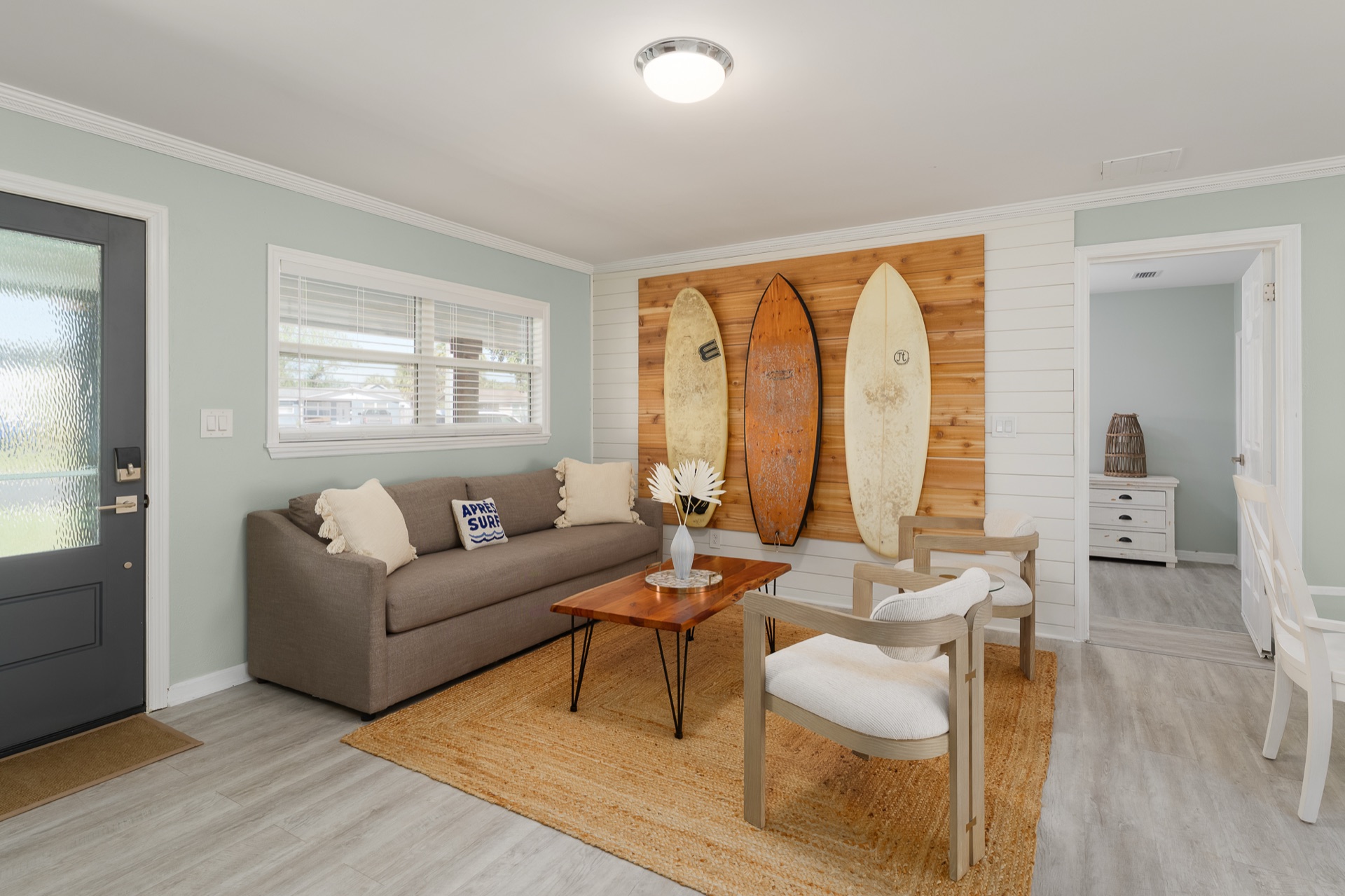 Living and dining area at Shell Yeah with a jute rug and an open sightline to the sunroom